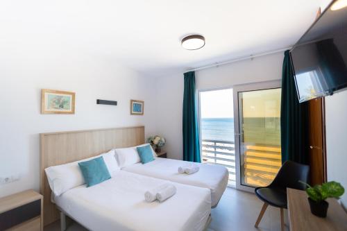 a living room with a white couch and a large window at Hotel Mediterráneo by Croma in Estepona