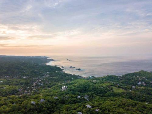 an aerial view of the ocean and a city at Casa La Distancia Mazunte Sustainable House in Mazunte