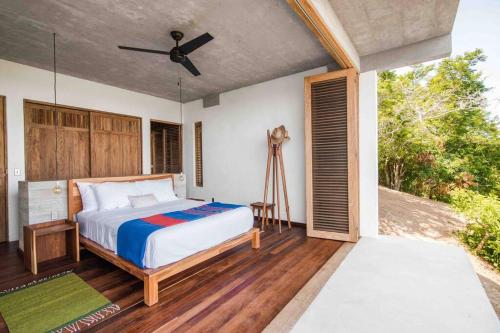 a bedroom with a bed and a ceiling fan at Casa La Distancia Mazunte Sustainable House in Mazunte
