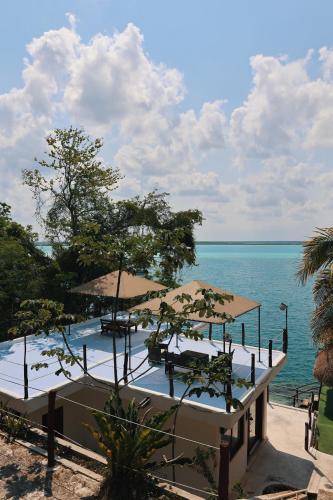 a resort with a pool with umbrellas and the ocean at Tucán Villages Bacalar Lagoon Front in Bacalar