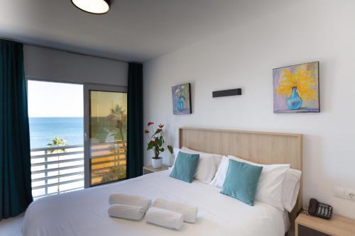 um quarto com uma cama e vista para o oceano em Hotel Mediterráneo em Estepona