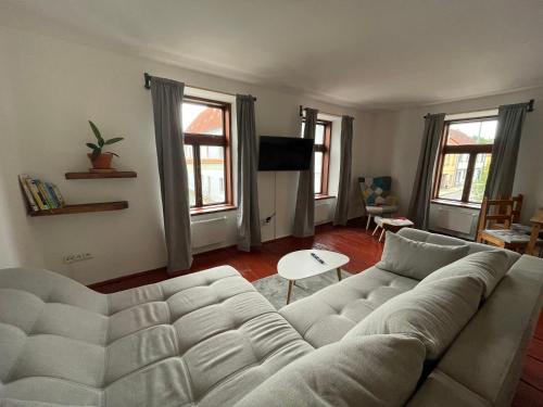 a living room with a large white couch at Apartmán U Špinarů in Třešť