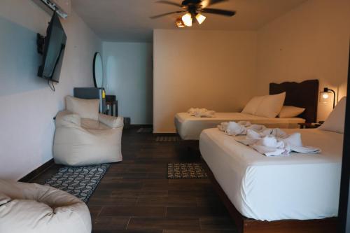 a living room with two beds and a couch at Tucán Villages Bacalar Lagoon Front in Bacalar