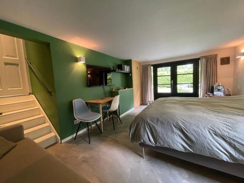 een slaapkamer met een bed en een tafel en stoelen bij La Grange 28 in Bergen op Zoom