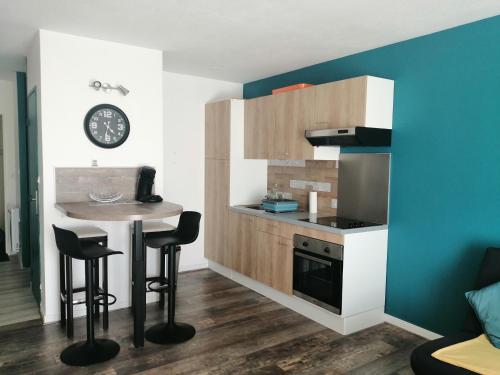 - une petite cuisine avec une table et un comptoir dans l'établissement Le DÉLICE DES DUNES, à Seignosse