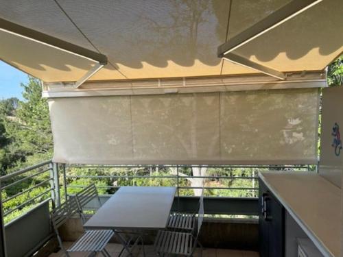 un balcon avec une table et des chaises sur un balcon dans l'établissement Cocon terrasse piscine, à Villeneuve-lès-Avignon