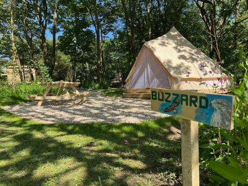 a tent with a sign in front of it at Glamping at Camp Corve in Chale
