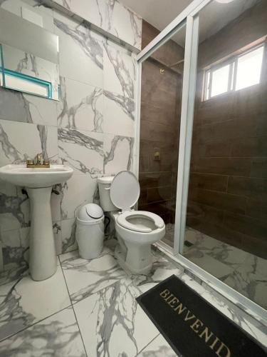 a bathroom with a toilet and a sink at Hotel cacao spa cozumel in Cozumel