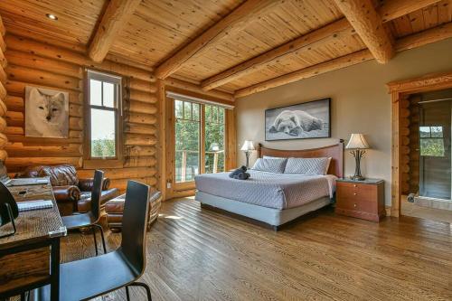 a bedroom with a bed in a room with wooden walls at Eagle's Nest in Saint-Faustin