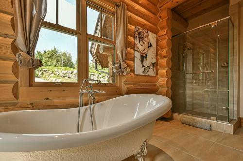 a large bathroom with a tub and a window at Eagle's Nest in Saint-Faustin