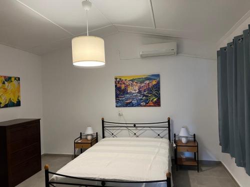 a bedroom with a bed and a painting on the wall at Kanala house in Kithnos