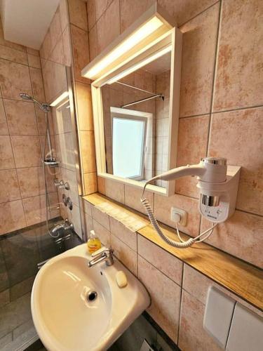 a bathroom with a sink and a mirror at Apartment 7-10 in Oberschleißheim