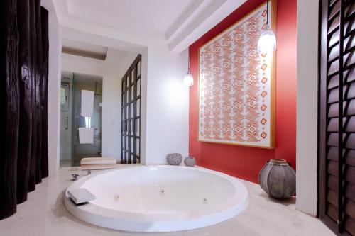 bañera grande en una habitación con pared roja en Luxury Beach Residences, en Puerto Morelos