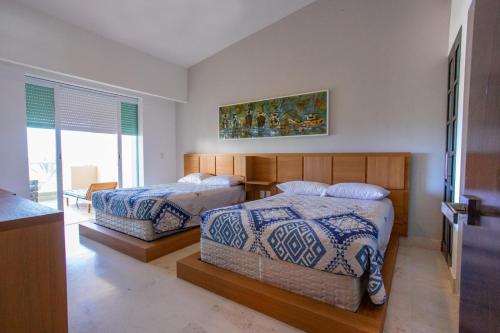 1 dormitorio con 2 camas y ventana en Luxury Beach Residences, en Puerto Morelos