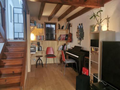 - un salon avec un piano et un bureau dans l'établissement Jolie maison cosy avec terrasse 600m plage, à Saint-Jean-de-Luz