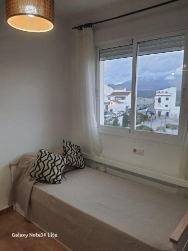 a bed in a room with a large window at Manilva chill in Manilva