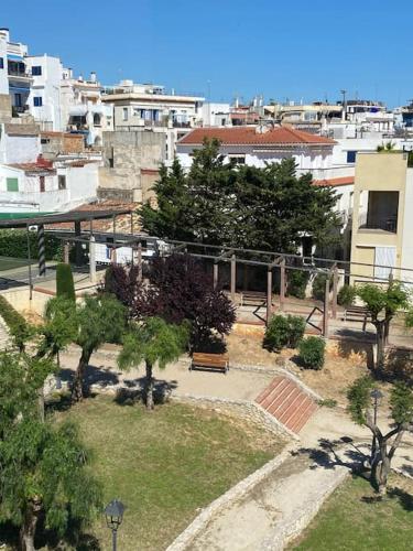 un parco con panchina e alberi e edifici di Pure Chill Apartment Sitges centre beach a Sitges