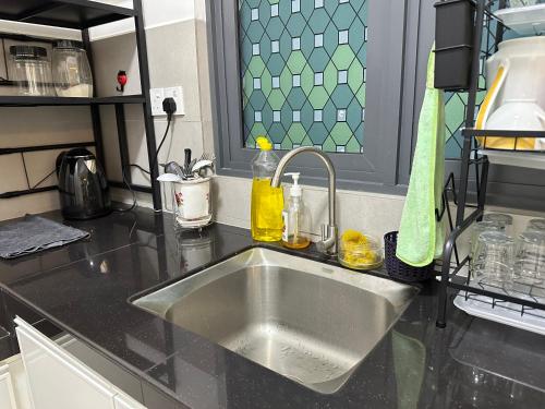 Holiday Inn Stay 3B2R Meritus Residensi Perai في بيراي: طاولة مطبخ مع حوض حديد قابل للصدأ