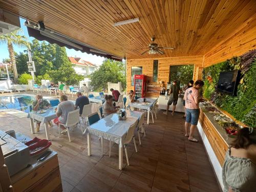 a group of people sitting at tables on a patio at Amsterdam Otel Economic Room in Kemer