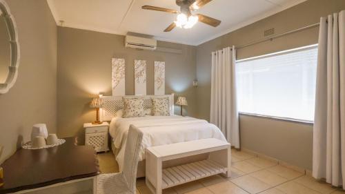 a bedroom with a white bed and a window at Stay at Percy Self Catering House in Nelspruit