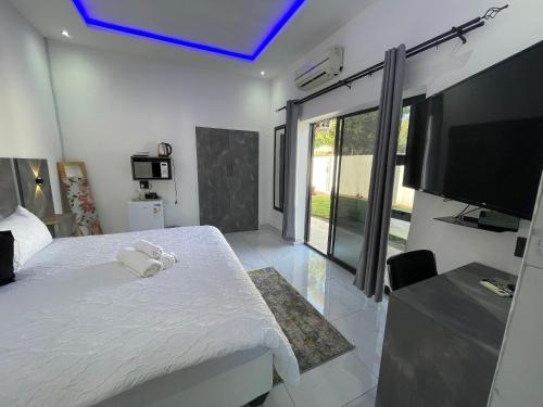 a bedroom with a large white bed with a tv at Rabi’s guesthouse in Mahikeng