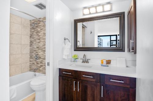 a bathroom with a sink and a mirror at Breathtaking Ocean View 1 BR Condo with Free Parking! in Honolulu