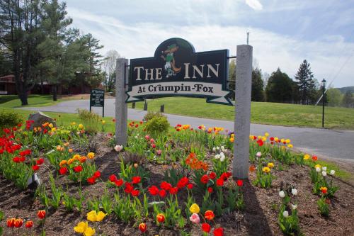 a sign for the inn with flowers in a garden at The Inn at Crumpin-Fox in Bernardston