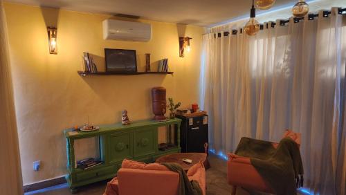 een woonkamer met 2 stoelen en een groene open haard bij Espaço Canela-de-Ema in Alto Paraíso de Goiás