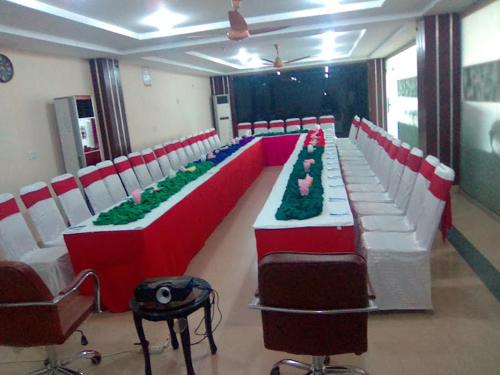 a conference room with red and white tables and chairs at Hotel La Flora in Multan