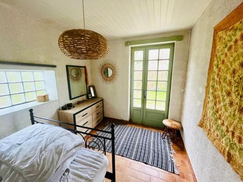 une chambre avec un lit et une porte verte dans l'établissement Mathannaki, à Vendays-Montalivet