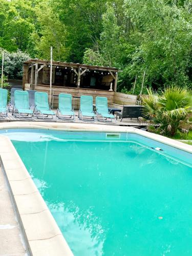 - une piscine avec des chaises bleues dans la cour dans l'établissement Mathannaki, à Vendays-Montalivet