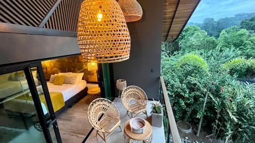 a room with a bed and chairs on a balcony at Namu Garden Hotel & Spa - Adults Only in Puerto Viejo