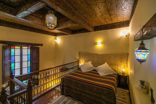 a bedroom with a bed and a stained glass window at Ryad Mabrouka in Fès