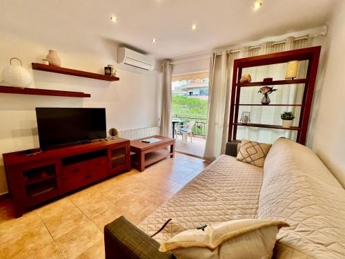een woonkamer met een bank en een flatscreen-tv bij Apartaments Platja d’Aro in Platja  d'Aro