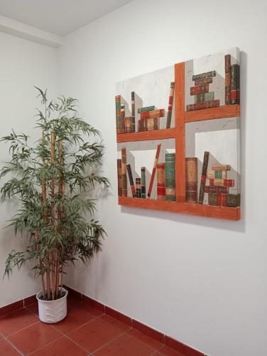 a plant in a pot next to a painting on a wall at Apartamentos La Piedra de Nájera in Nájera