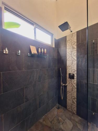 a bathroom with a shower with a glass door at Alloro Jungle Villas in Puerto Viejo