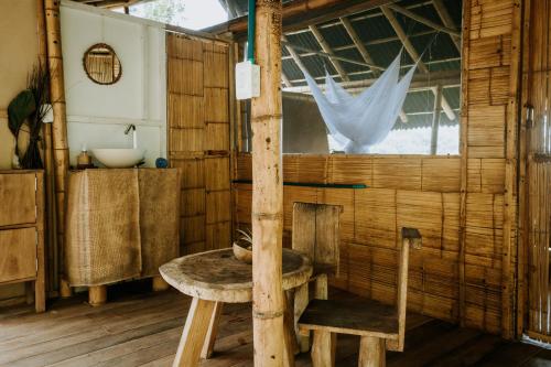 um quarto de madeira com uma mesa e uma cadeira em Finca La Selvita em Buritaca