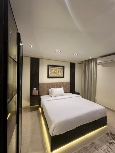 a bedroom with a large white bed in a room at Crowne Pyramids View inn in Cairo