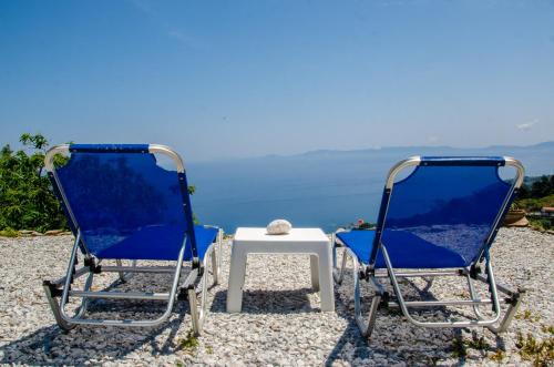 two chairs and a table with a view of the ocean at Villa Pounta Family in Glóssa