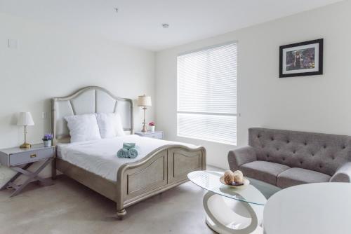 - une chambre blanche avec un lit et un canapé dans l'établissement Suite Little Tokyo Los Angeles, à Los Angeles