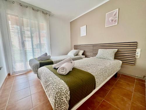 een slaapkamer met 2 bedden en een raam bij Apartaments Platja d’Aro in Platja  d'Aro
