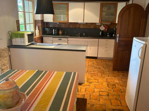 une cuisine avec des armoires blanches et un comptoir dans l'établissement Domaine de la source, à Montignac