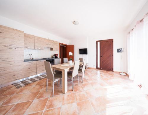 a kitchen and dining room with a table and chairs at Cas'Aurora in Tresnuraghes