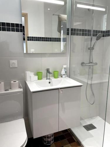 une salle de bain blanche avec une douche et un lavabo dans l'établissement Charmante maison individuelle proche du Touquet, à Cucq
