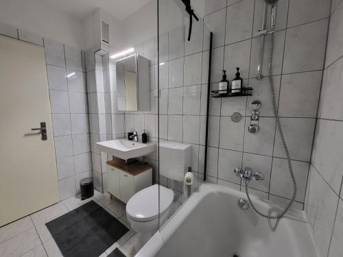 een badkamer met een bad, een toilet en een wastafel bij Zentrumsnahe Wohlfühloase in Kassel