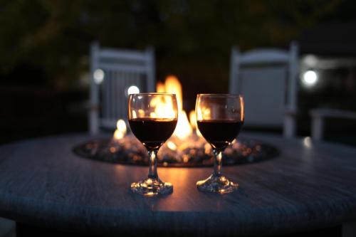two glasses of wine sitting on a table with a fire place at The Inn at Crumpin-Fox in Bernardston