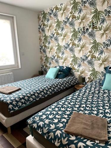 - une chambre avec 2 lits dotés d'oreillers bleus dans l'établissement Charmante maison individuelle proche du Touquet, à Cucq