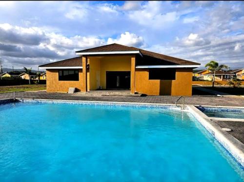 ein Haus mit einem blauen Pool davor in der Unterkunft Welcome to Barefoot Bliss Short Term Rental 