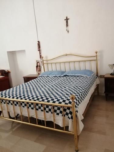 a bed in a room with a cross on the wall at PROF OLIVETO ANTICo in San Marco in Lamis
