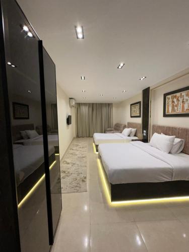 Habitación de hotel con 2 camas y pared de cristal. en Crowne Pyramids view inn, en El Cairo
